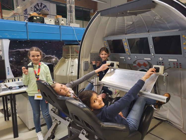 vier Mädchen in einem Flugsimulator