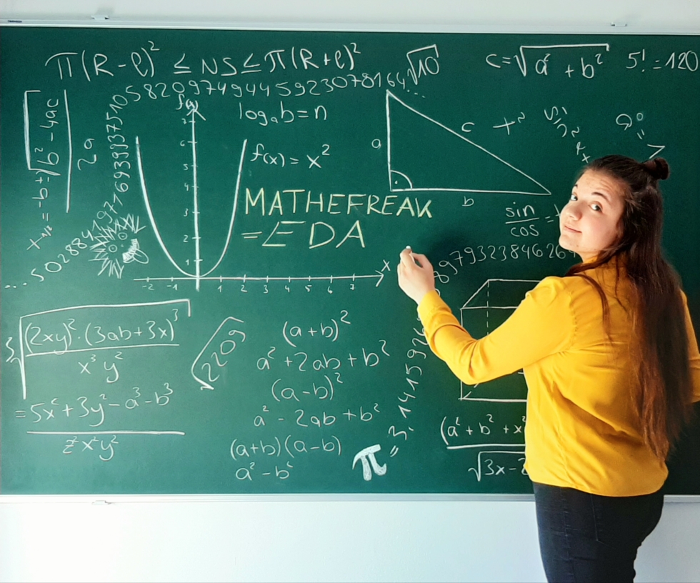 Mädchen vor einer Tafel mit mathematischen Formeln