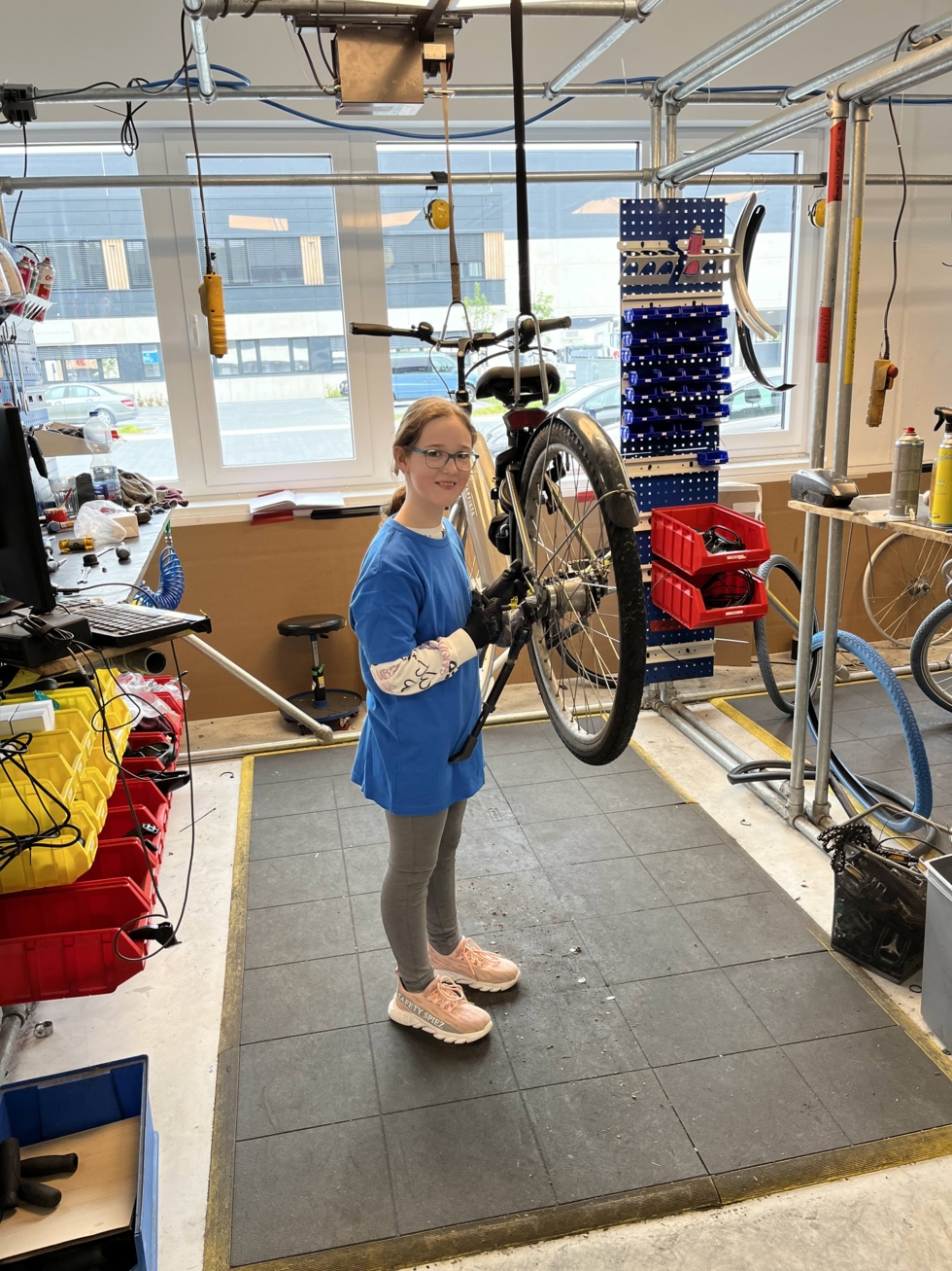 Mädchen repariert ein Fahrrad.