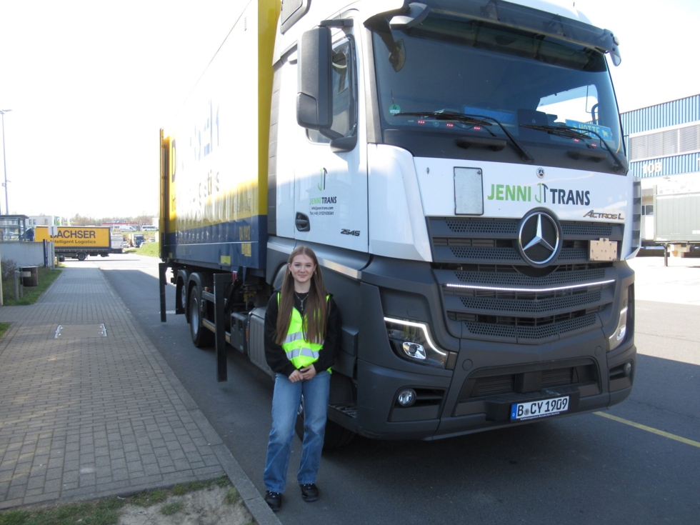 Girls'Day-Teilnehmerin steht in Warnweste vor einem Mercedes-Lkw