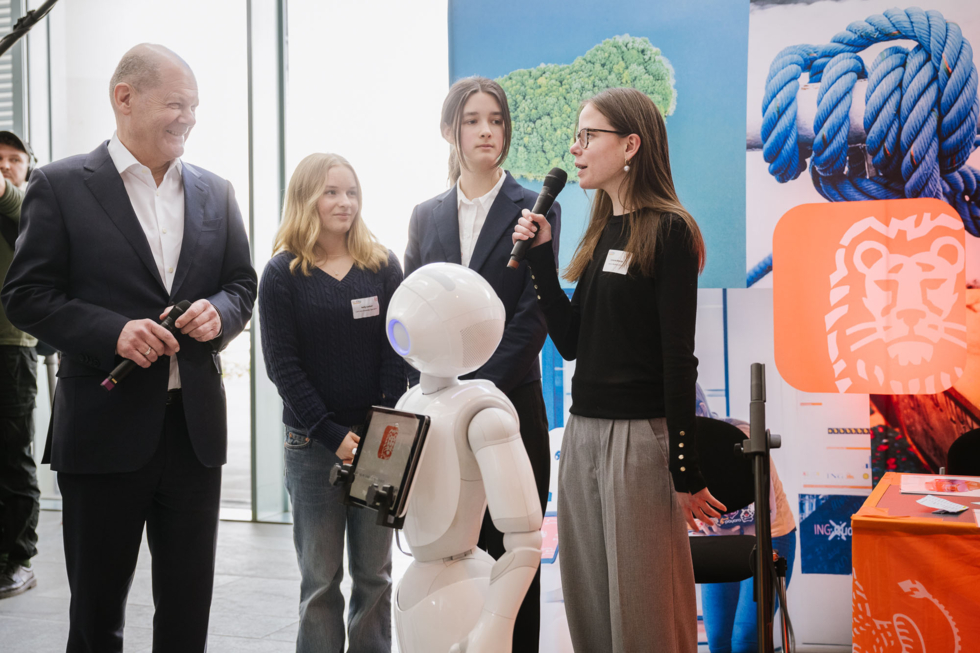 Schülerinnen mit Bundeskanzler Scholz und KI-Roboter Pepper