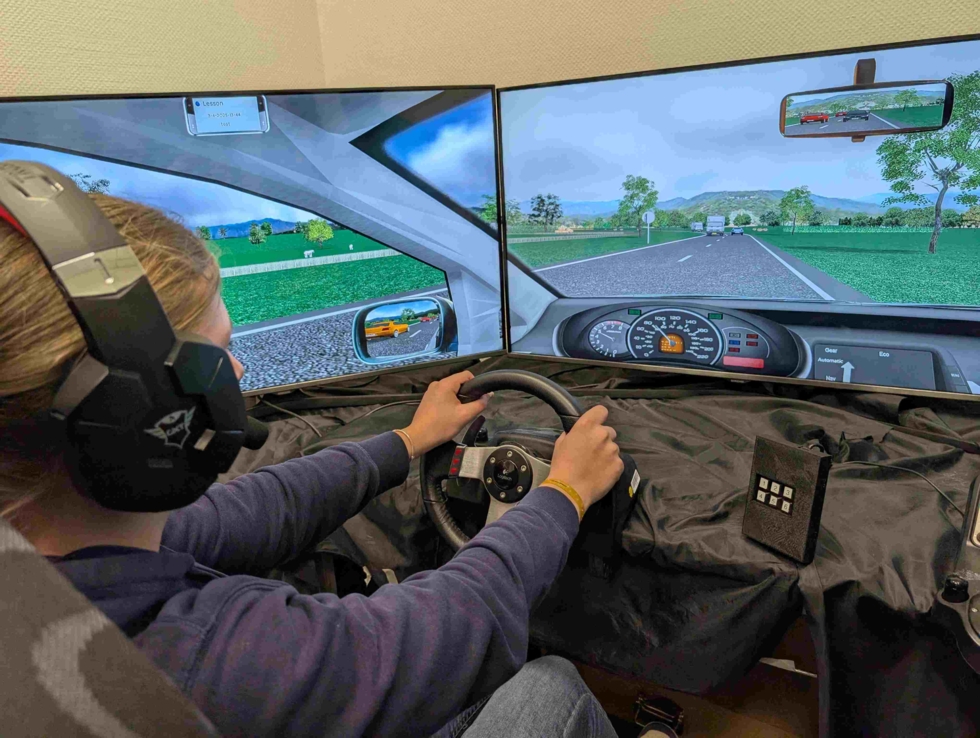 Person mit Kopfhörern sitzt in einem Fahrsimulator