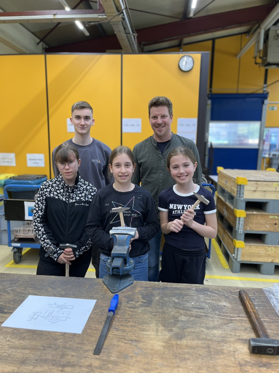 Girls'Day-Teilnehmerinnen mit Mitarbeitern in Werkstatt