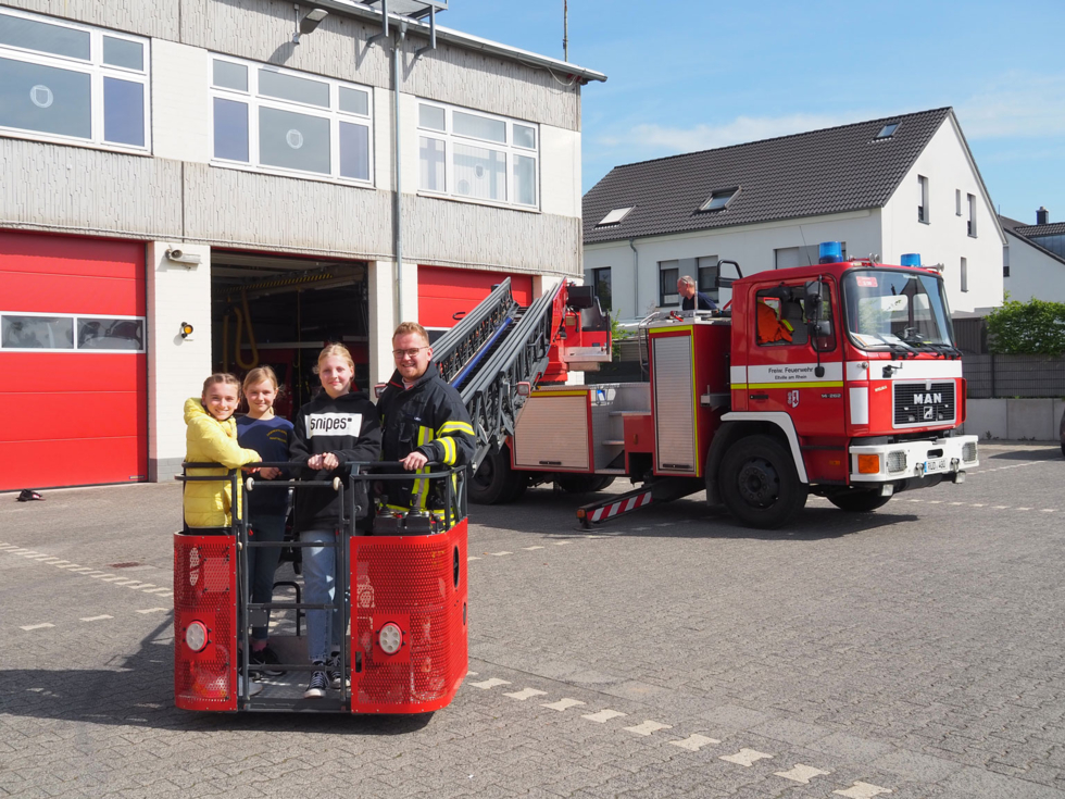 Girls'Day-Teilnehmerinnen und Feuerwehrmann im Rettungskorb