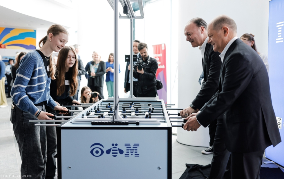 Kanzler Olaf Scholz und Marc Reinhardt spielen mit zwei Teilnehmerinnen Tischkicker.