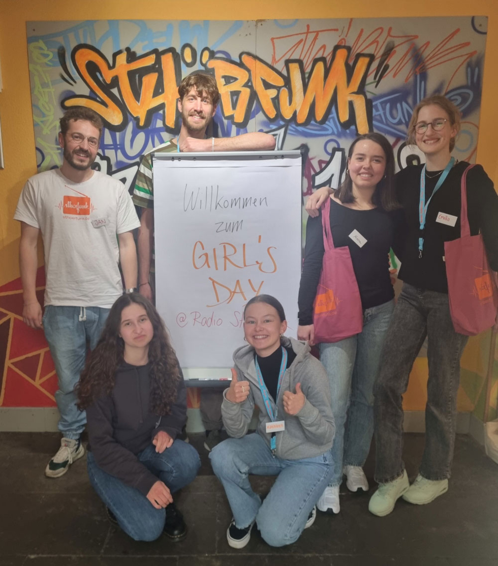 Girls'Day-Teilnehmerinnen und Radiomitarbeiter/innen vor Girls'Day-Flipchart