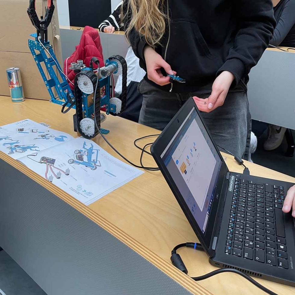 Girls'Day Teilnehmerin beim ausprobieren eines kleinen Roboters