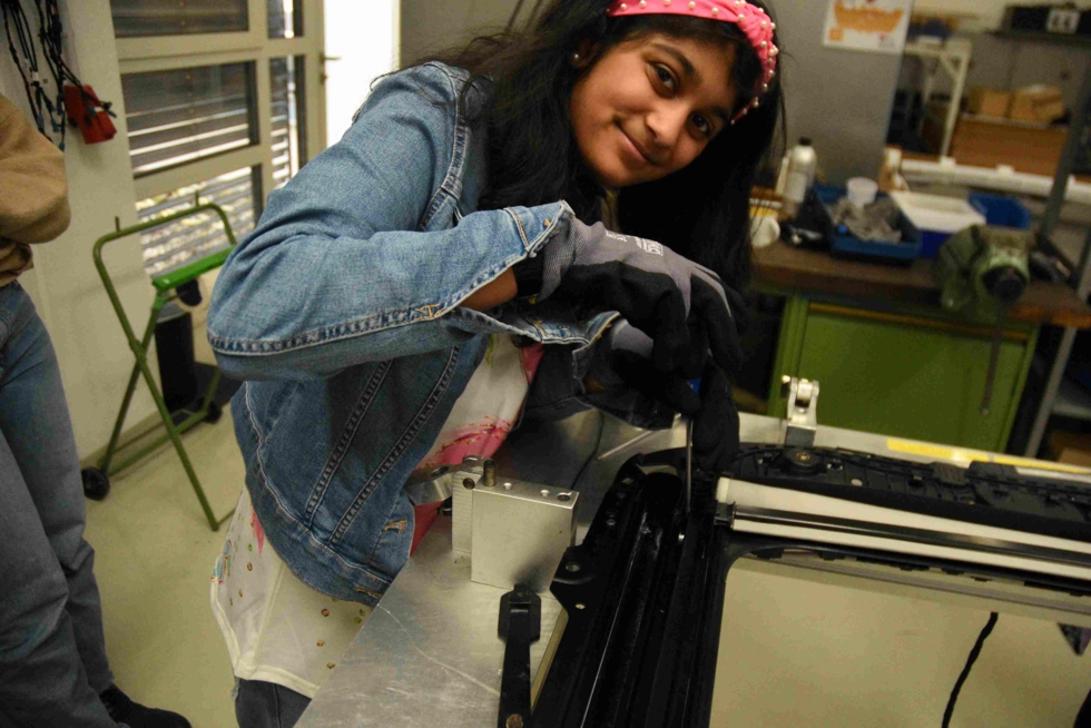 Girls' Day-Teilnehmerin bedient eine Maschine in einer Werkstatt