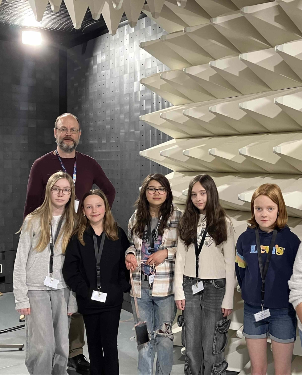 Gruppe von fünf Girls' Day-Teilnehmerinnen und einem Mitarbeiter in einem Raum mit schallabsorbierenden Wänden und großen weißen Schaumstoffplatten