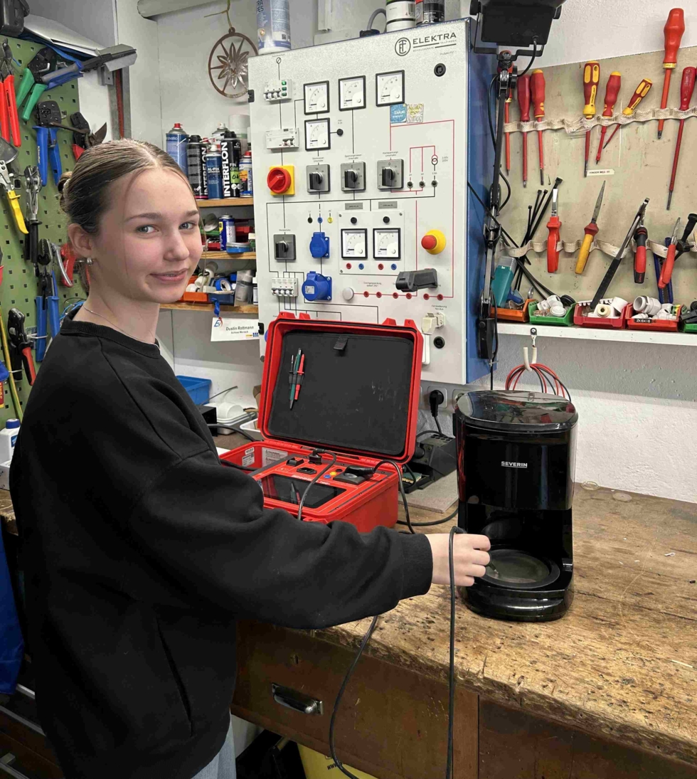 Girls'Day-Teilnehmerinnen mit elektronischen Geräten in Werkstatt