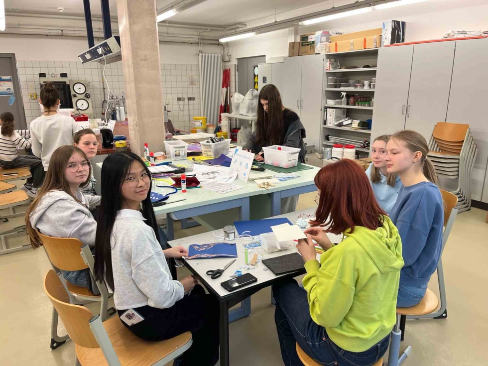 Girls'Day-Teilnehmerin experimentieren und basteln am Gruppentisch